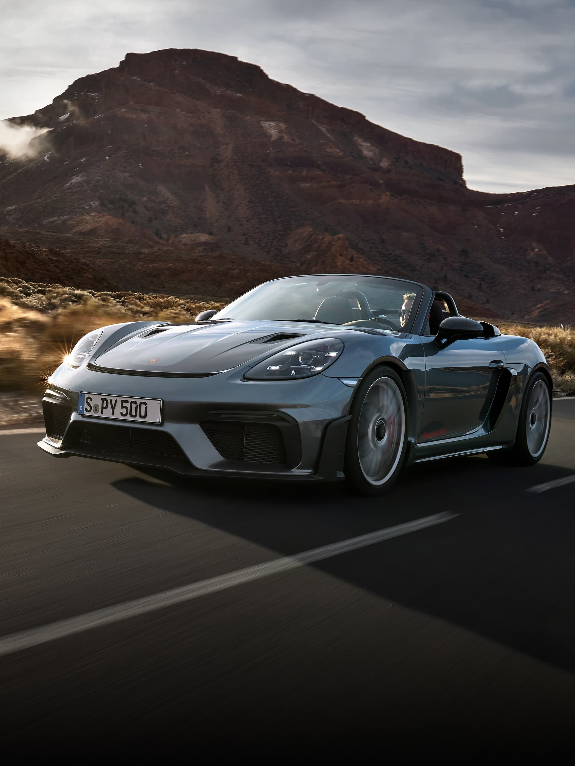 Porsche 718 Spyder RS fährt auf der Straße zwischen Felsformationen.